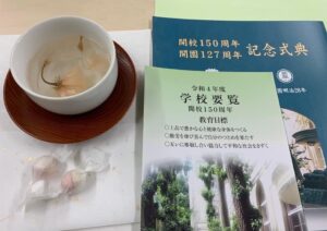 記念式典のパンフレットと桜茶、茶菓子