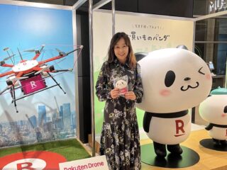 楽天ドローンの隣でパンダのマスコットを手にしたわたし